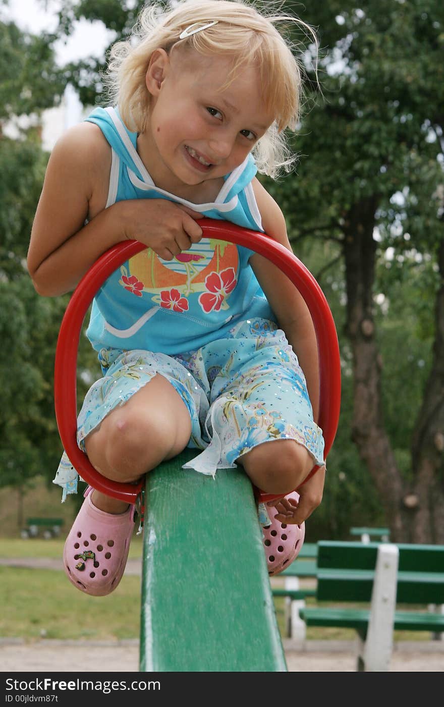 Pretty childhood girl swaying on the balance swing