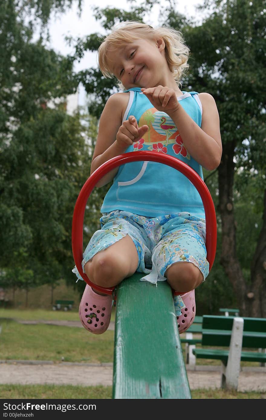 Pretty childhood girl swaying on the balance swing