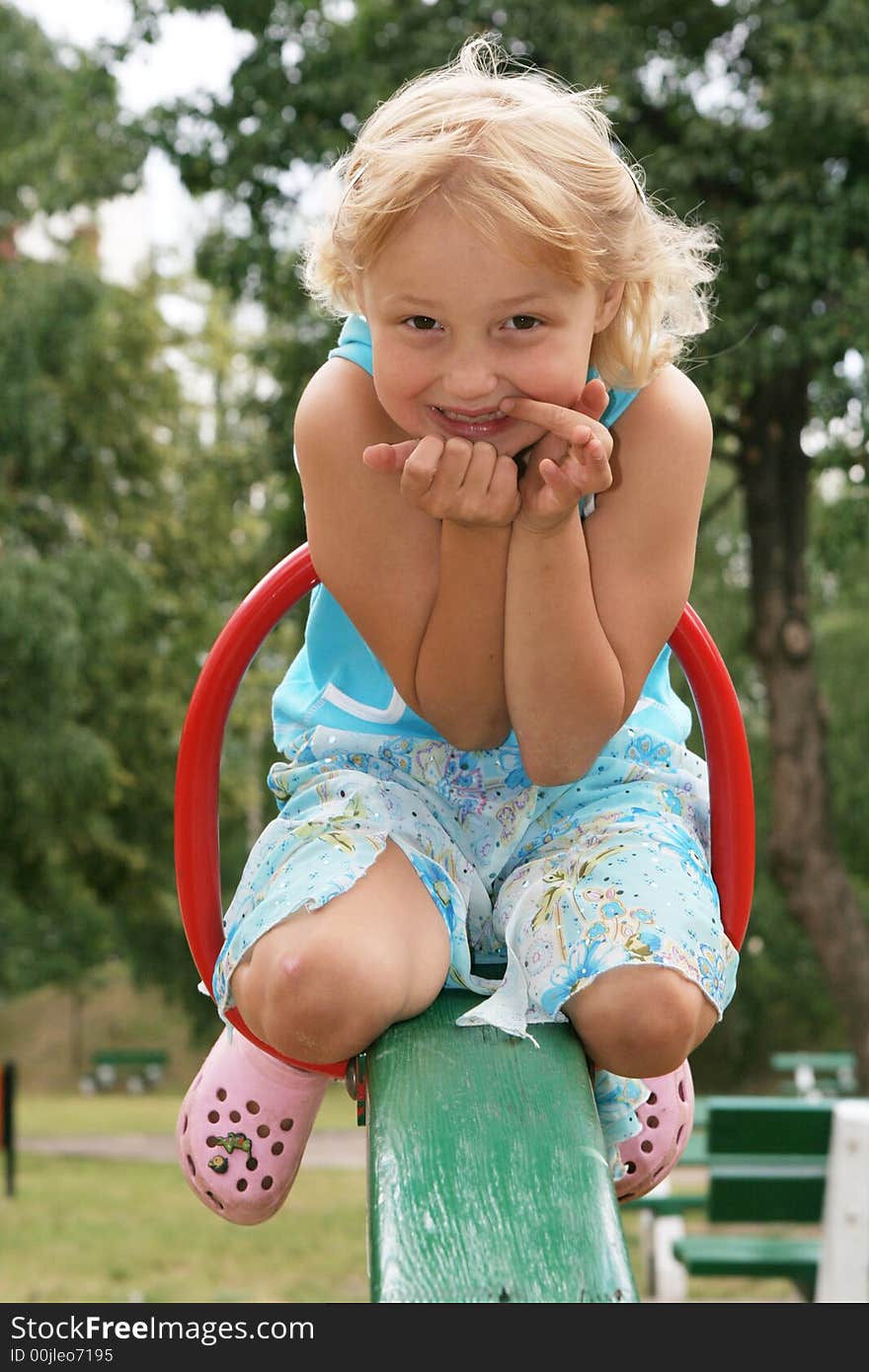 Pretty childhood girl swaying on the balance swing