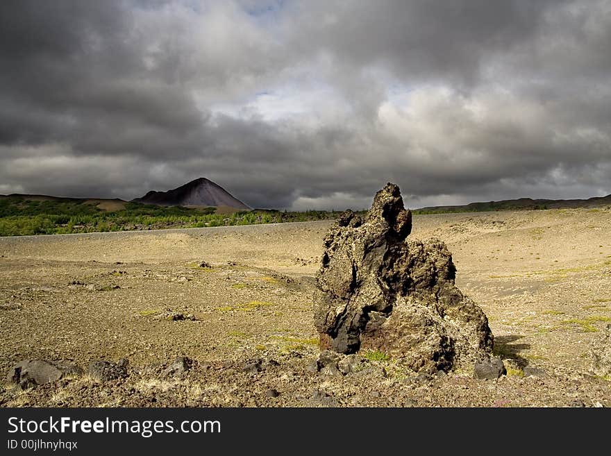 Volcanic rock under cloudy sky. Volcanic rock under cloudy sky