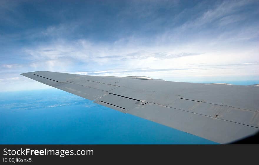 Sky and wing of a KC-135 military jet, in flight with a blue sky background. Sky and wing of a KC-135 military jet, in flight with a blue sky background