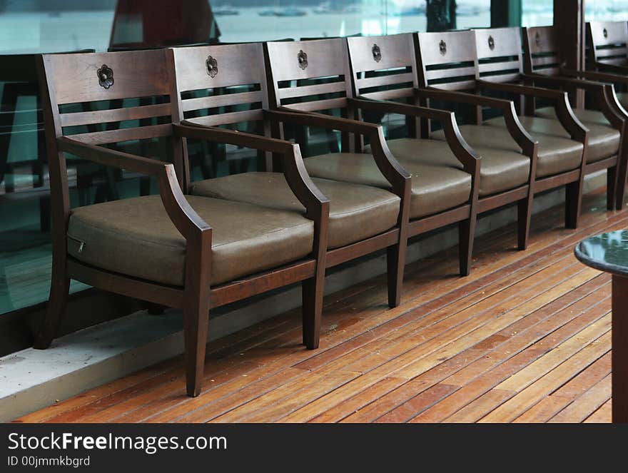 Row of wooden chairs along a wall.