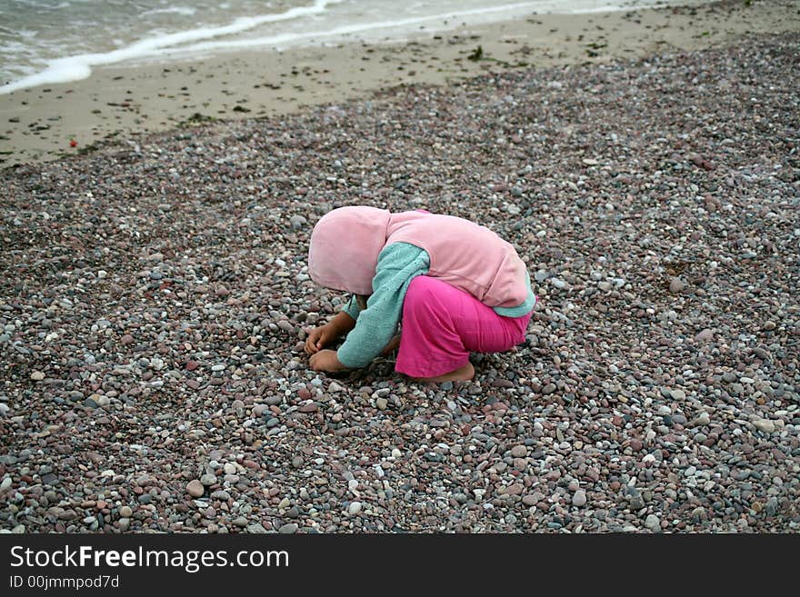 A girl playing with stones on the coast of Baltic sea. A girl playing with stones on the coast of Baltic sea