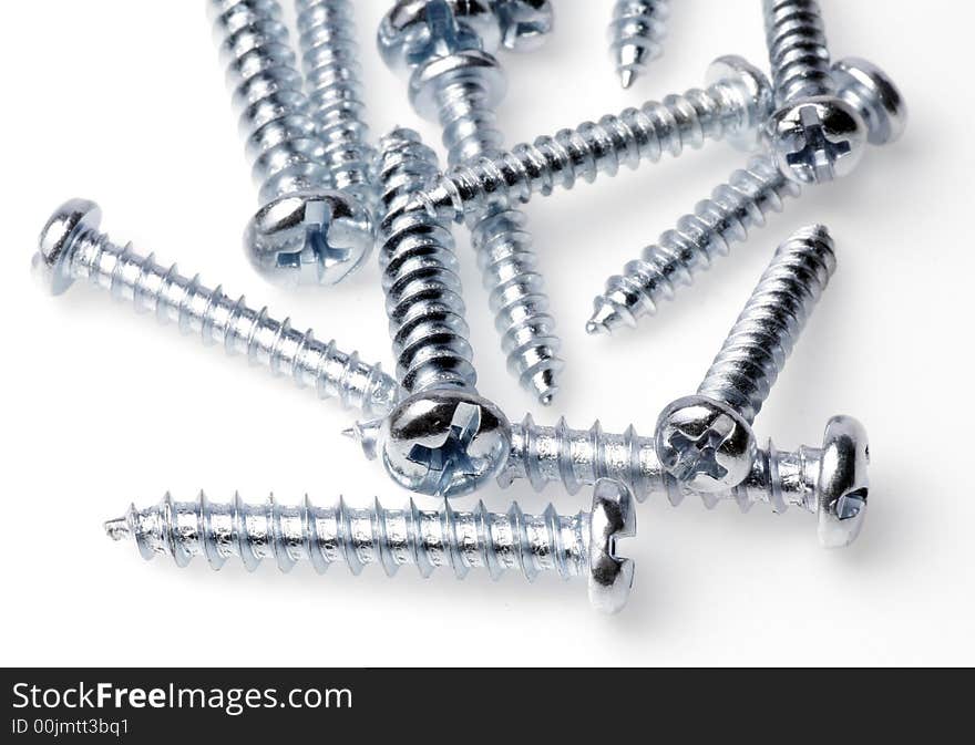 Macro Close-Up Of Spiral Metal Screws On A White Background, Focus On Front