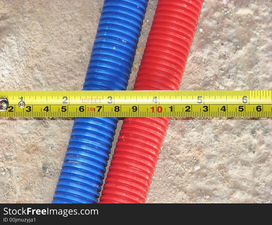 Yellow metallic ruler on blue and red tubes. Yellow metallic ruler on blue and red tubes.