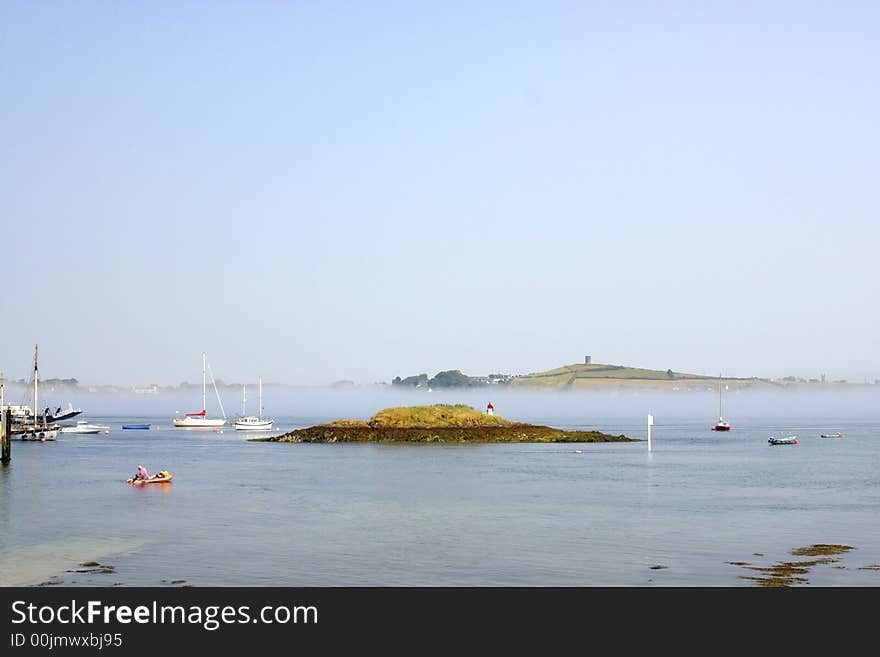 Island at a town of Ireland, with lighthouse and ships navigating