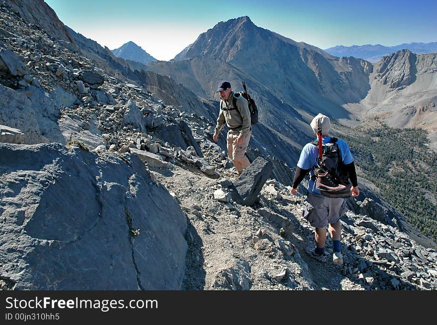 Several people climbing along rocky ridge on a trail. Several people climbing along rocky ridge on a trail