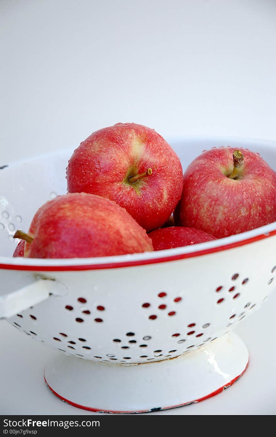 Red gala apples in white and red colander, white background. Red gala apples in white and red colander, white background