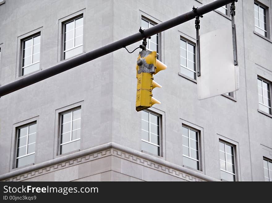 A traffic signal with a building in the middle of downtown. A traffic signal with a building in the middle of downtown.