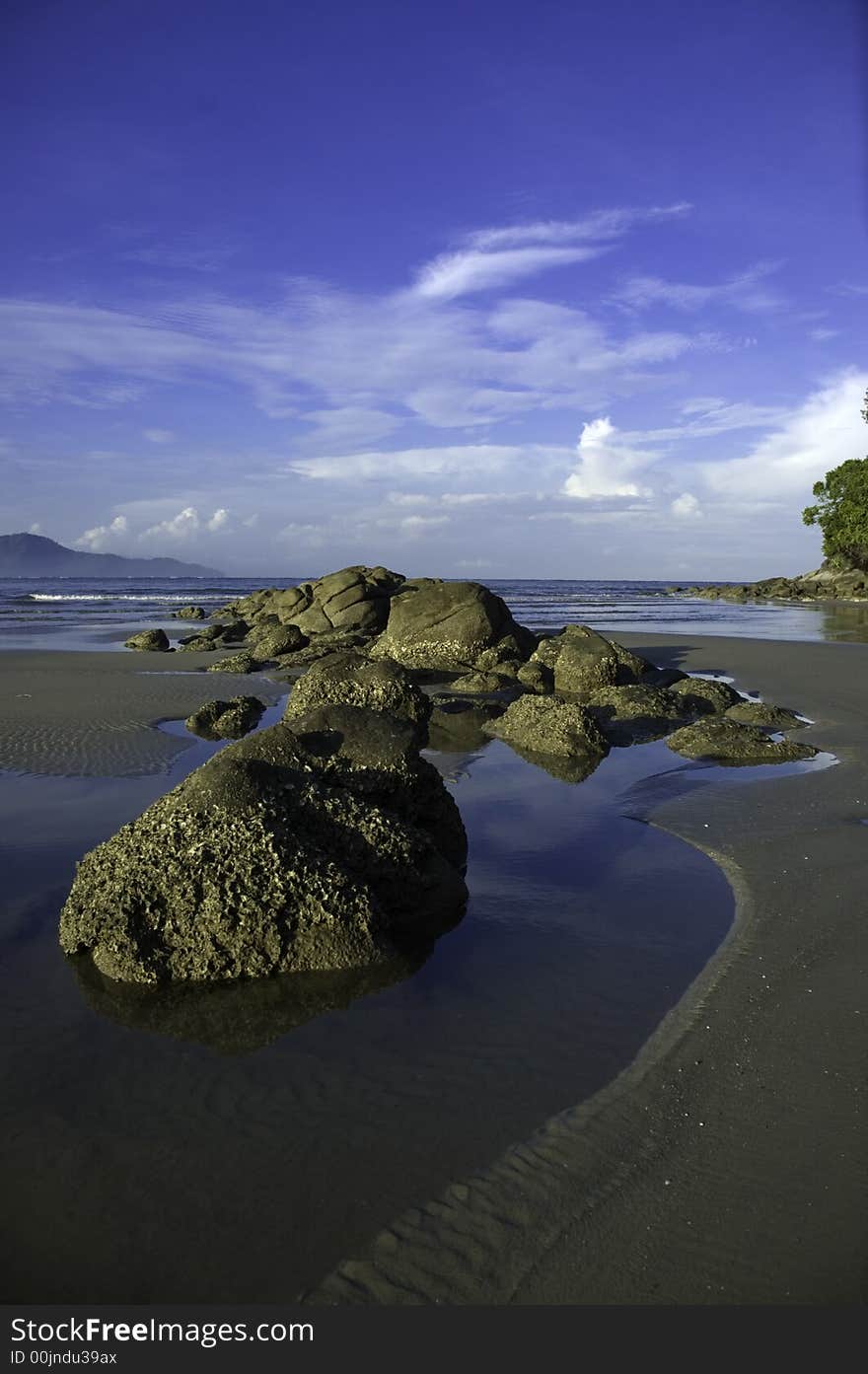 A cluster of rocks on the beach in a clear blue sky. A cluster of rocks on the beach in a clear blue sky