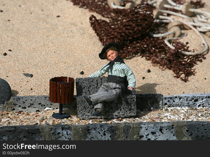 Miniature figurine of a fisherman on a bench