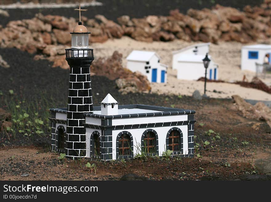 Miniature black and white lighthouse on a beach