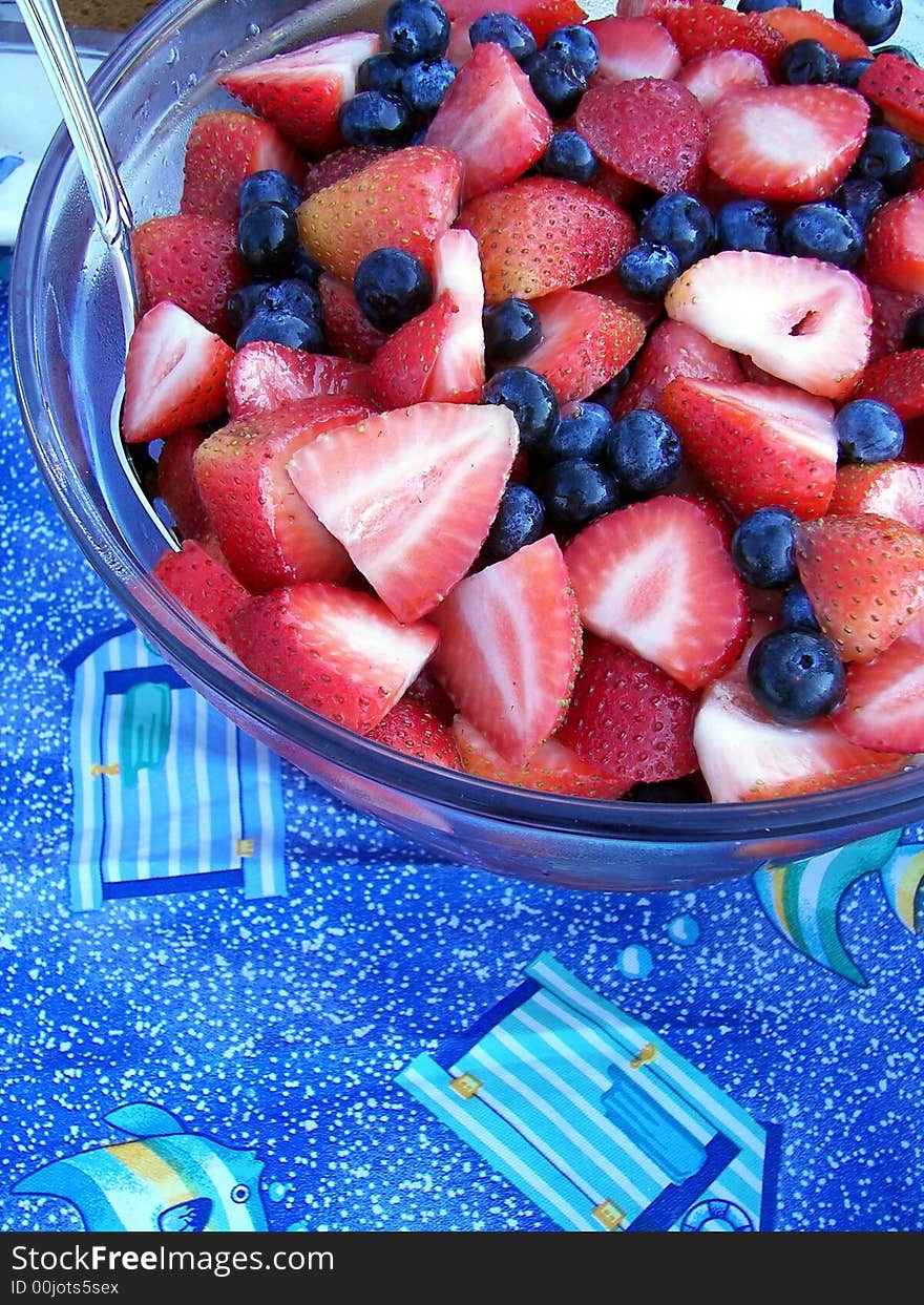 Fresh blueberries and strawberries in glass bowl on a fun tablecloth. Fresh blueberries and strawberries in glass bowl on a fun tablecloth.