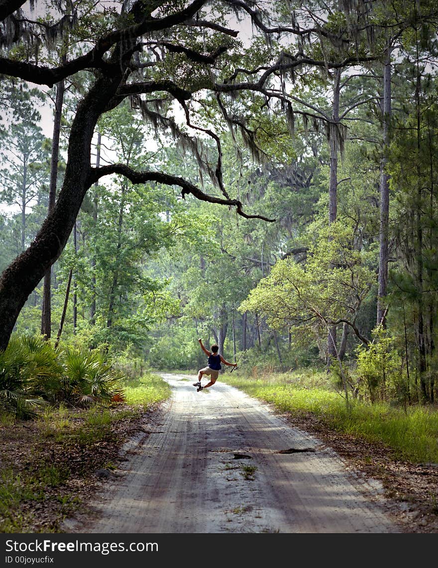 Woman going fishing jumps for joy on country road in Deep South of the U.S. Woman going fishing jumps for joy on country road in Deep South of the U.S.