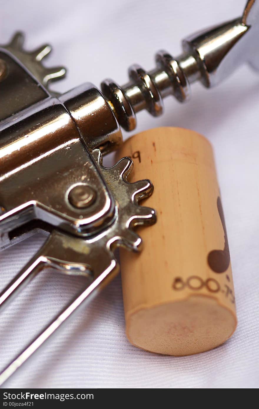 Corkscrew with cork on white tablecloth