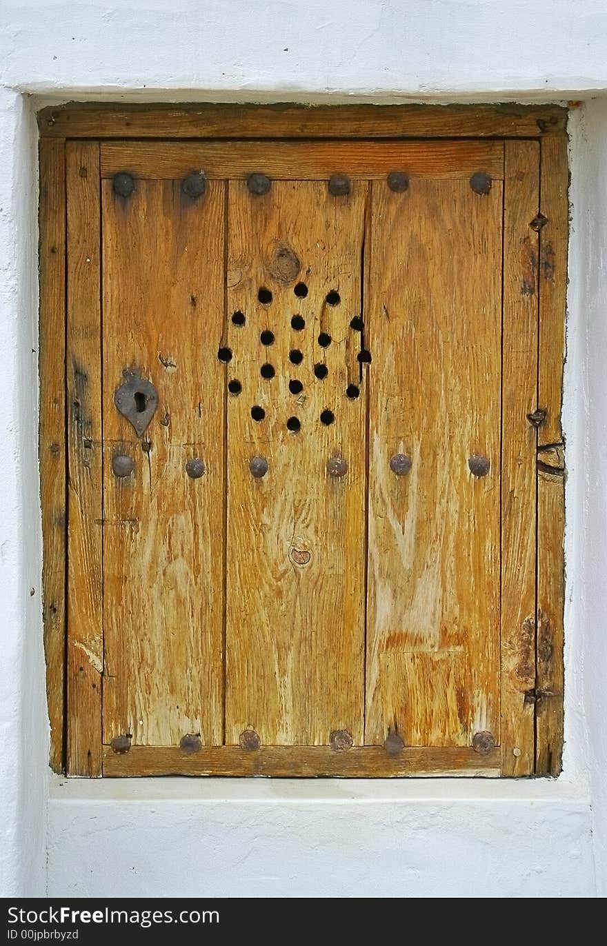 Brown wodd window of an rustic house in Ibiza, Spain