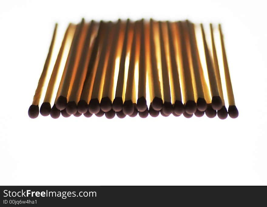 Many Wooden Matchsticks, Red Heads, White Background, Backlit, Shallow Depth Of Field. Many Wooden Matchsticks, Red Heads, White Background, Backlit, Shallow Depth Of Field