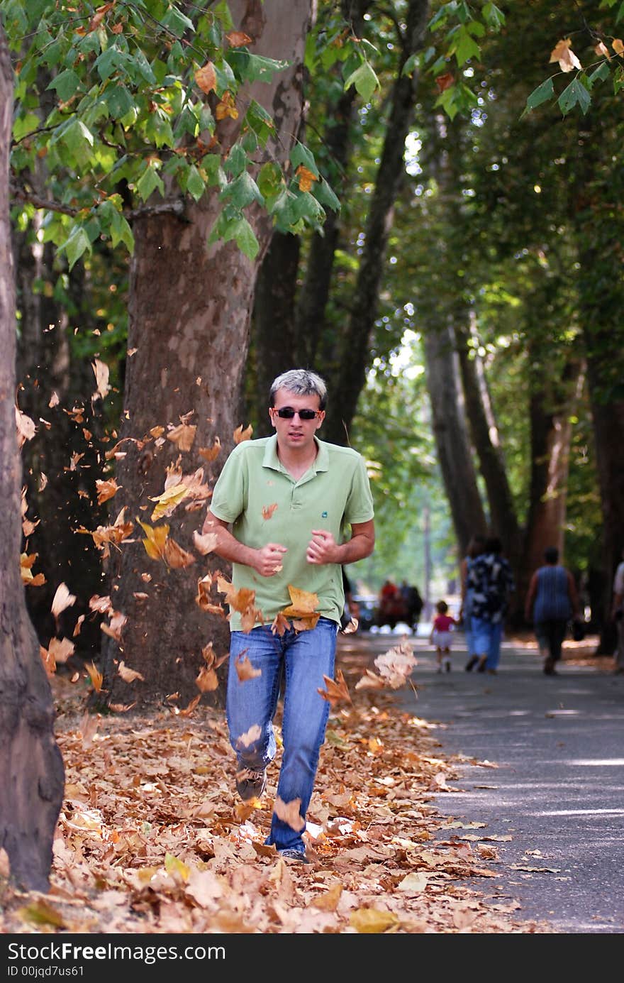 Man running in a forest leaves falling around