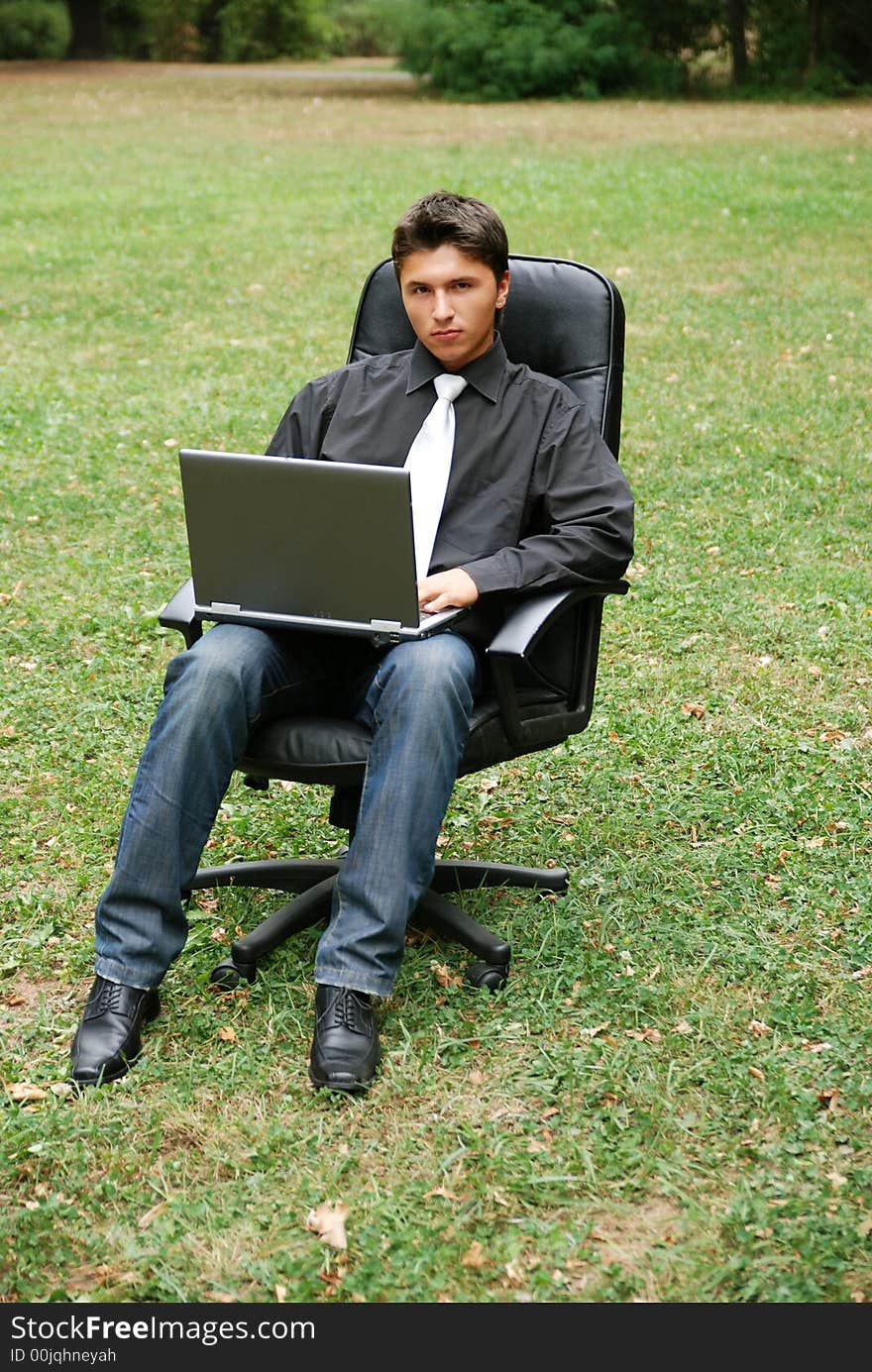 Man in field working on laptop