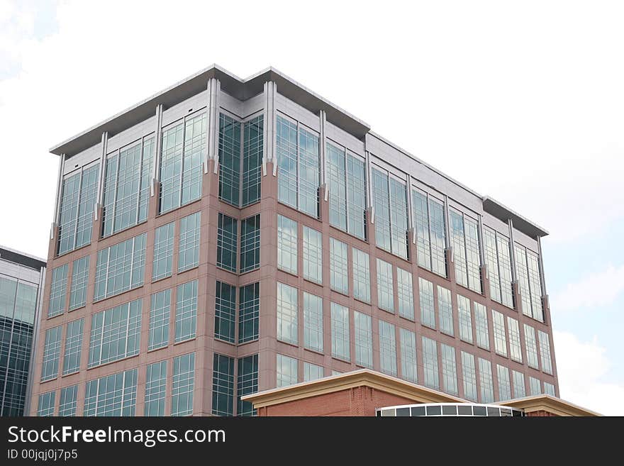 A modern brick and glass building with clouds. A modern brick and glass building with clouds