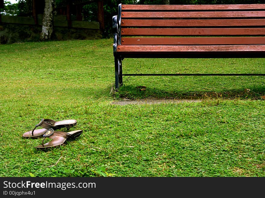 Single bench staying on the hill with the sandals left nearby. Single bench staying on the hill with the sandals left nearby