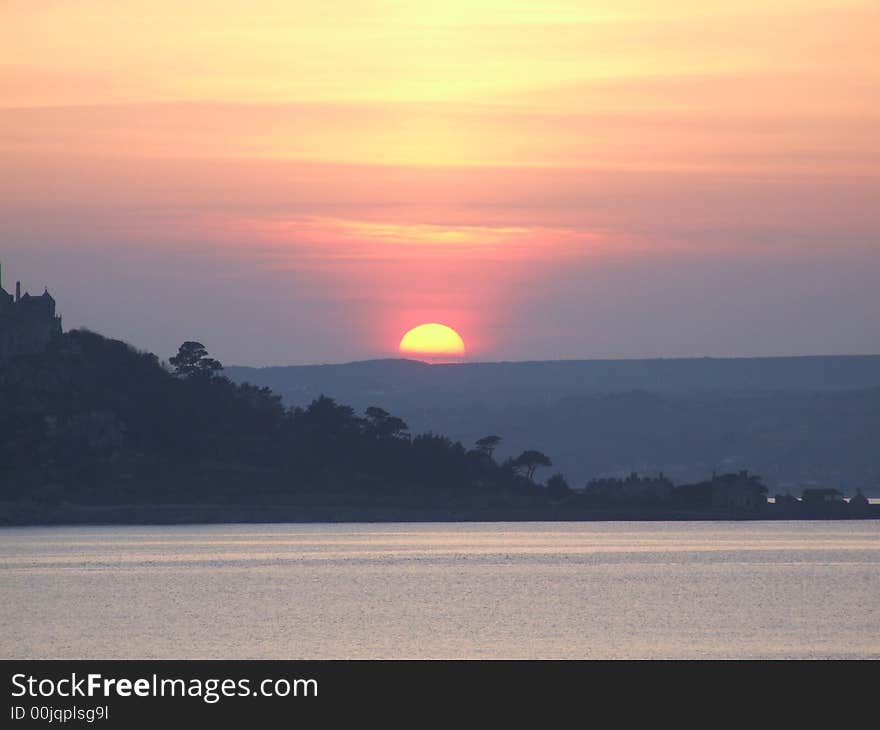 Sunset over sea in Cornwall by St. Michaels Mount