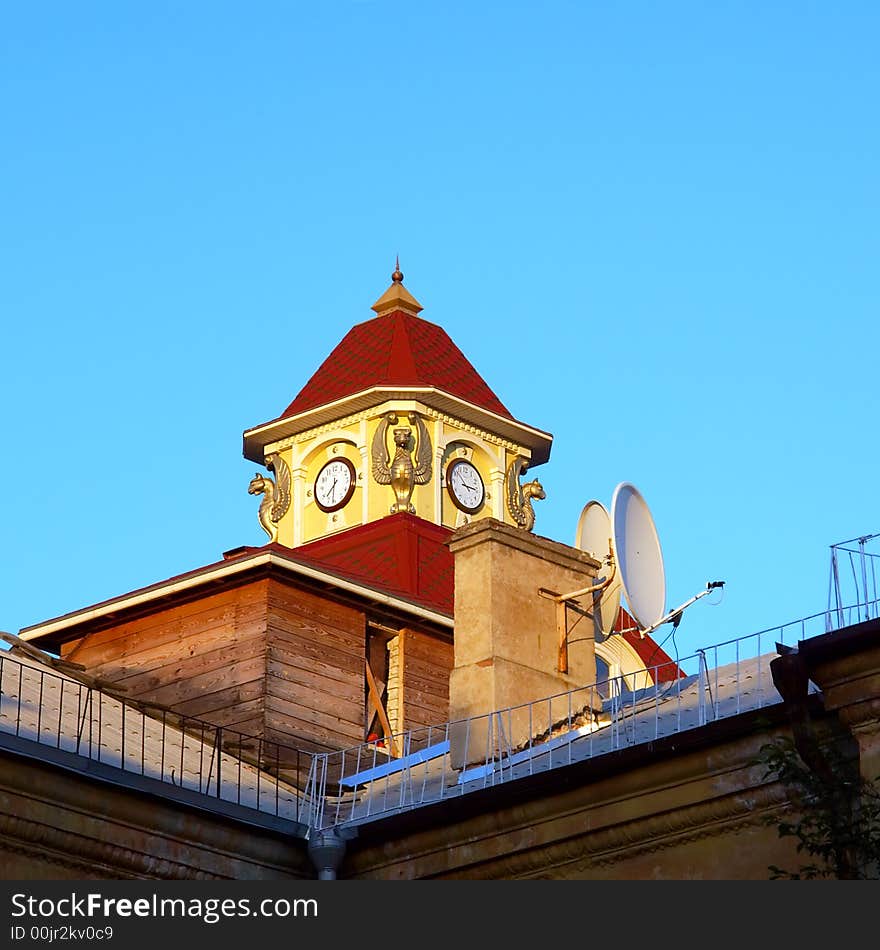 Old and modern - clock tower behind satellite dish in sunset light. Shot in Ukraine.