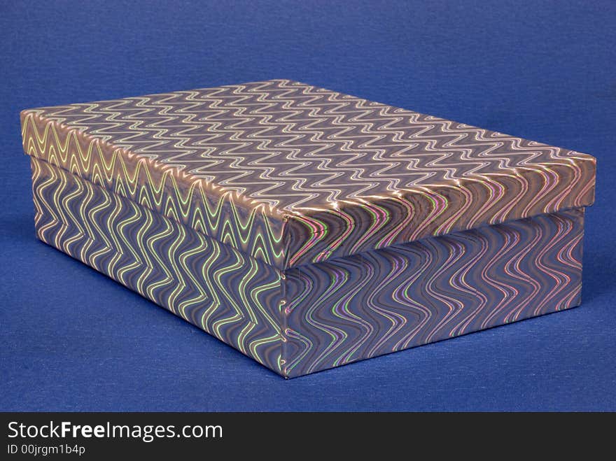 Silver coloured gift box with a multi coloured rainbow effect pattern