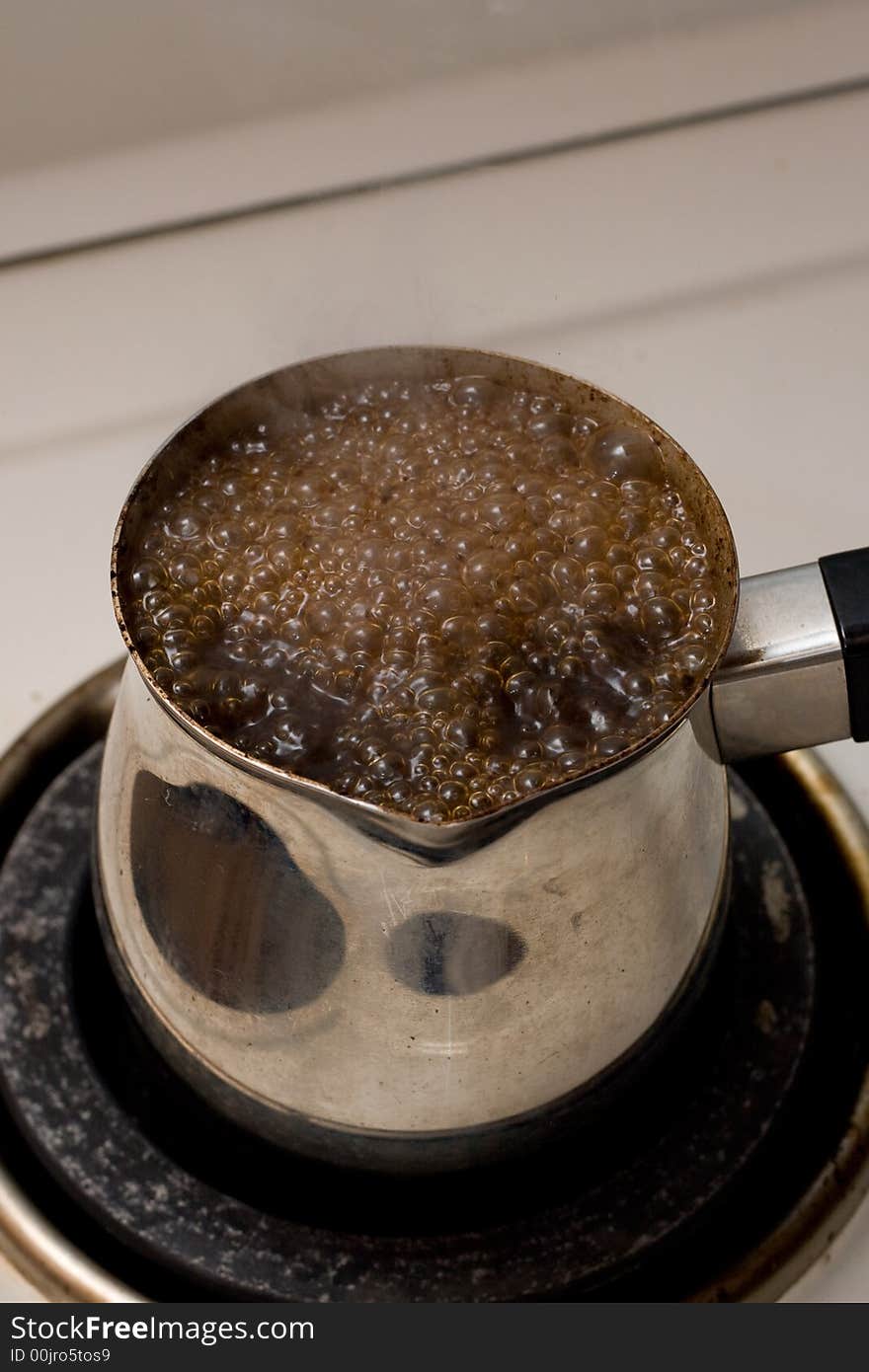 Preparing coffee in metal pot, and looks like it wants to run away from it. Preparing coffee in metal pot, and looks like it wants to run away from it...