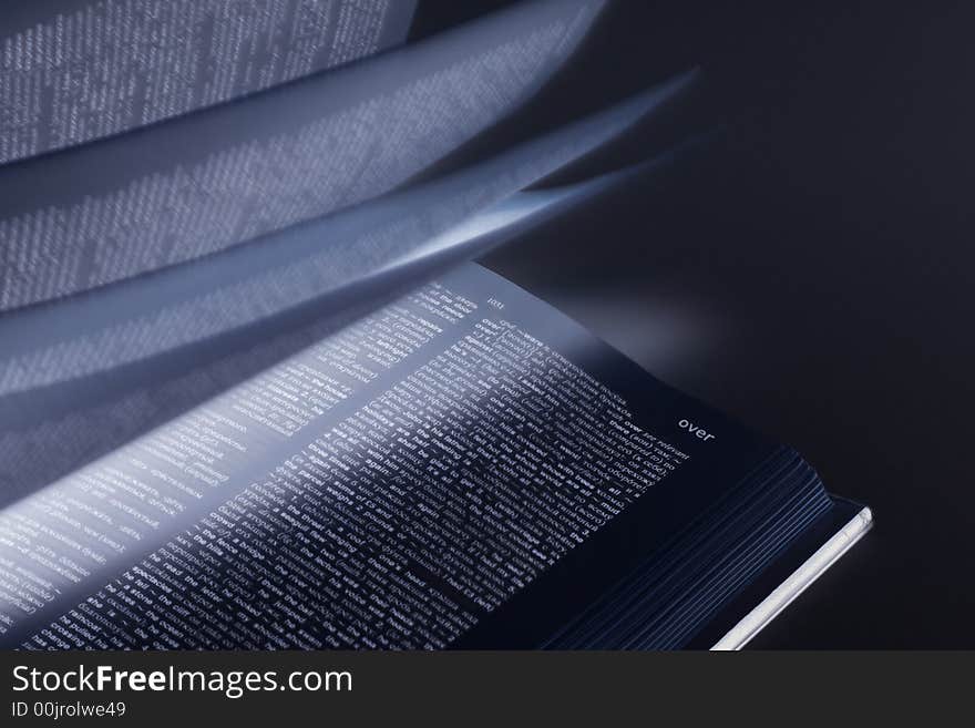 Word over on book with moving pages and mystical light