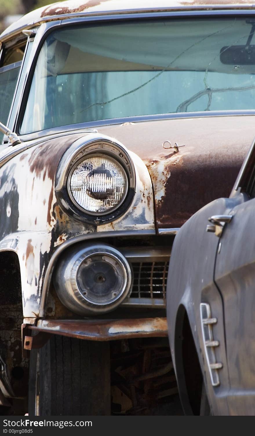 Headlight on a rusted and abandoned car in a wrecking yard. Headlight on a rusted and abandoned car in a wrecking yard.