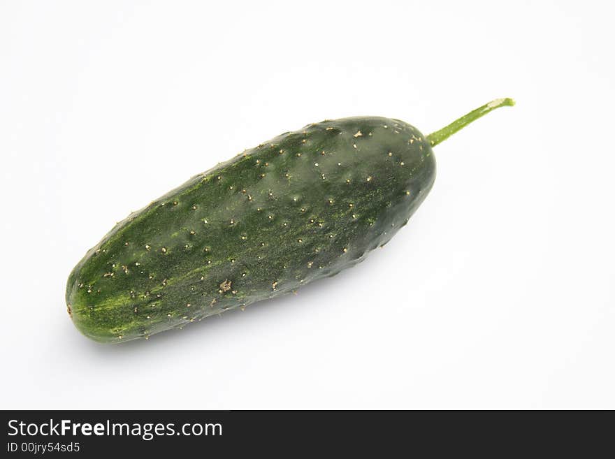 On a photo a green cucumber. The photo is isolated