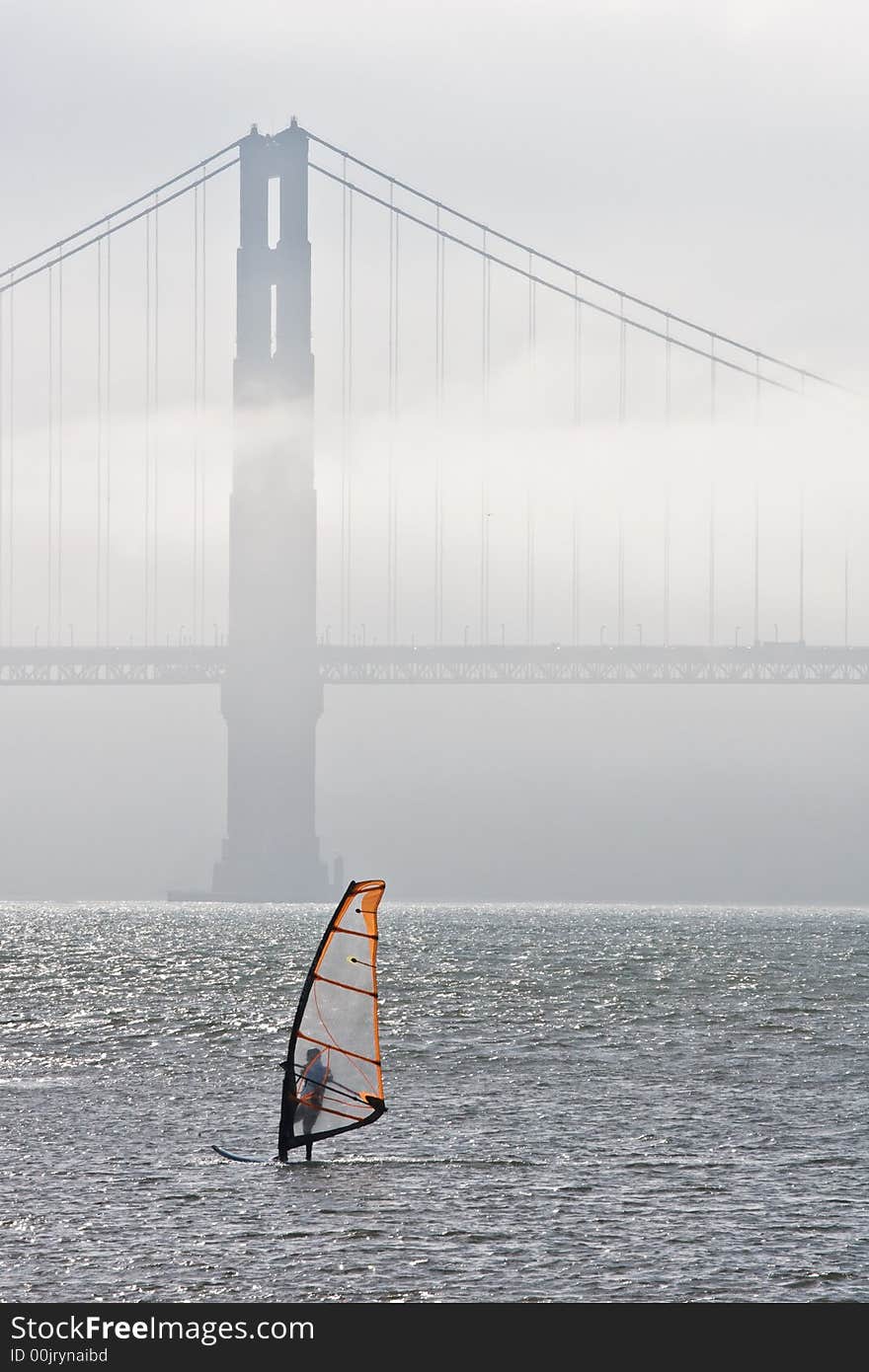 Windsurfing by Golden Gate bridge, fog is rolling in on the background