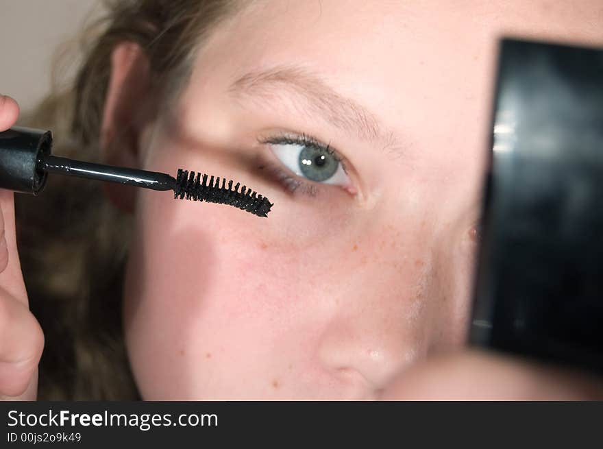 Young woman is putting up some mascara. Young woman is putting up some mascara