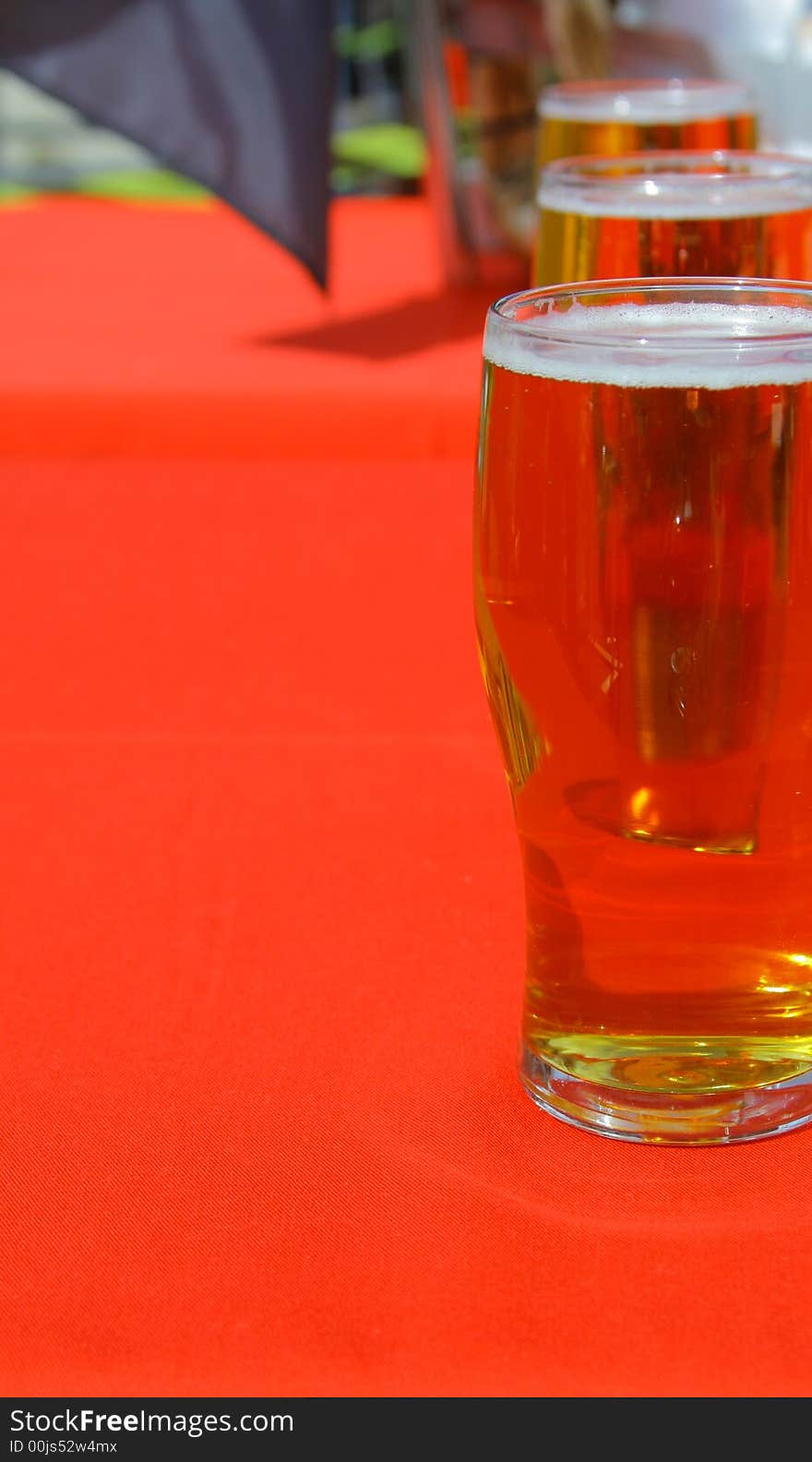 Three mugs of beer on a red table