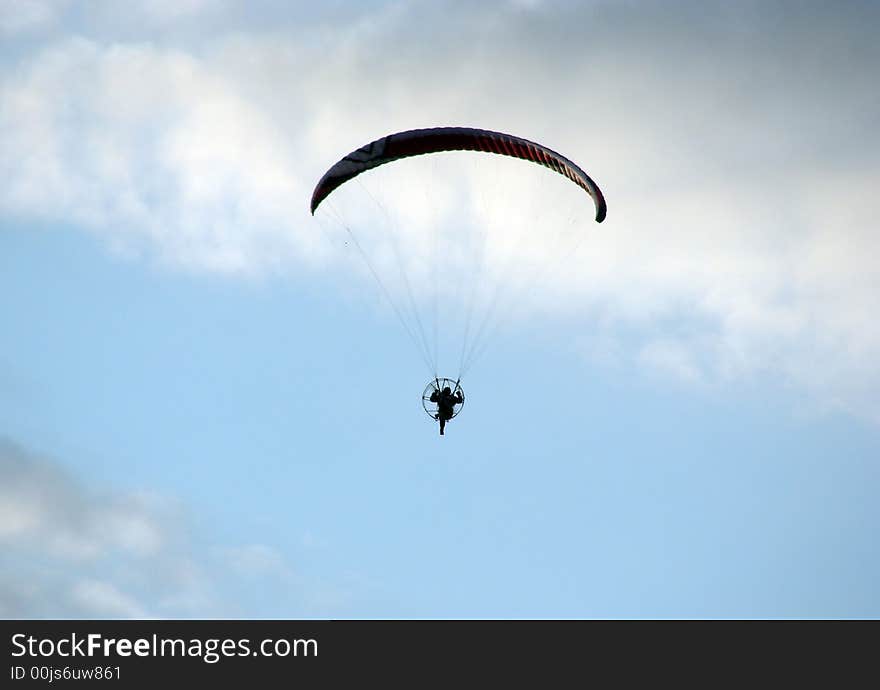 Lonely flyer in the storm clouds summer sky. Lonely flyer in the storm clouds summer sky