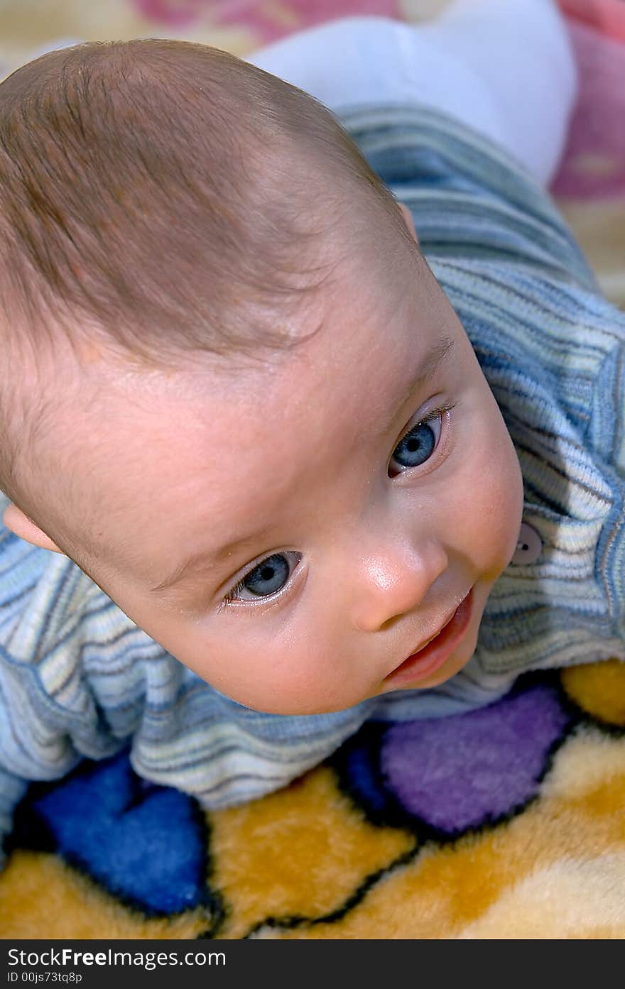 Little infant with big blue eyes laying on the stomach. Little infant with big blue eyes laying on the stomach