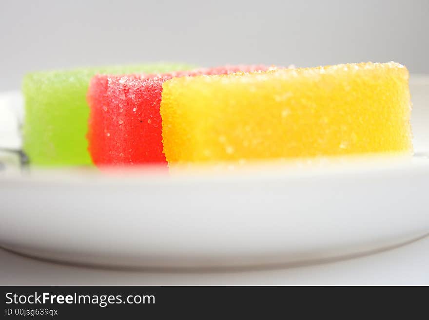 On a photo fruit candy of red, green yellow color.