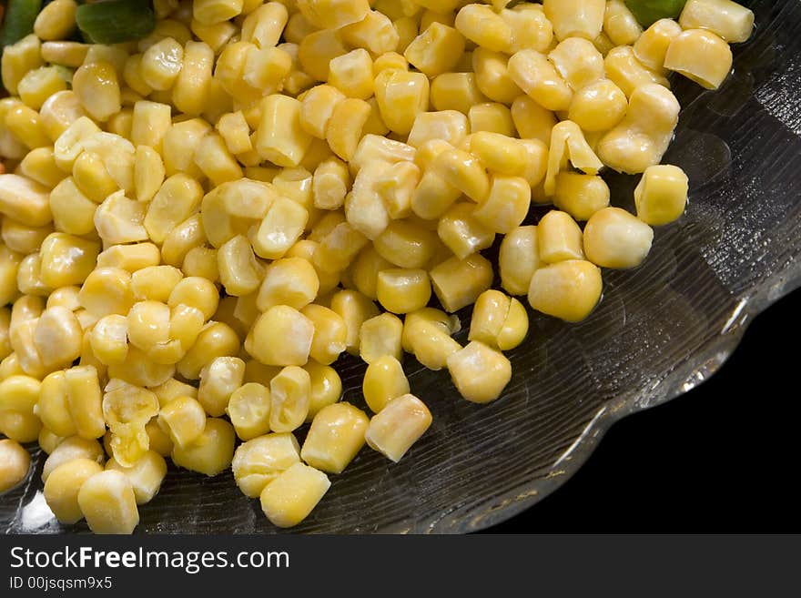 Precooked corn on a glass dish on a black background