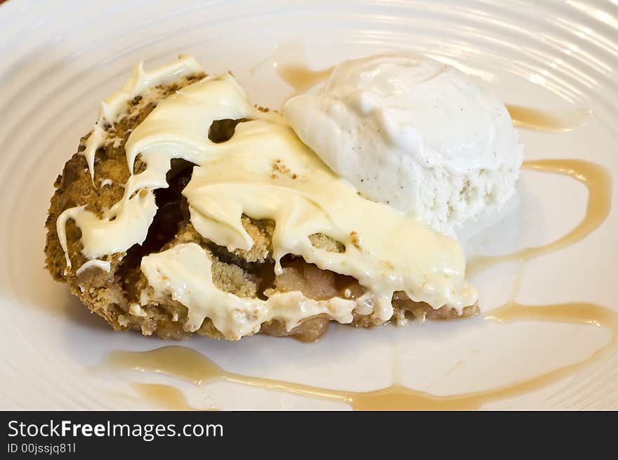 Slice of apple pie frosted with vanilla ice cream on white plate. Slice of apple pie frosted with vanilla ice cream on white plate