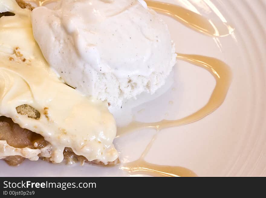 Slice of apple pie frosted with vanilla ice cream on white plate. Slice of apple pie frosted with vanilla ice cream on white plate