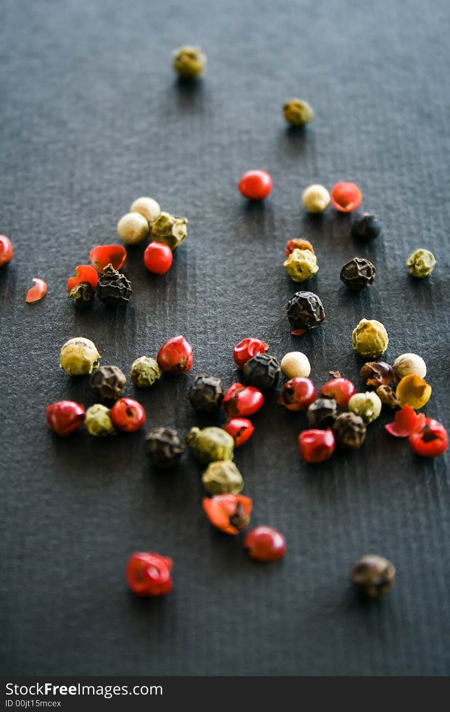 Colorful hot pepper grains on a black background. Colorful hot pepper grains on a black background