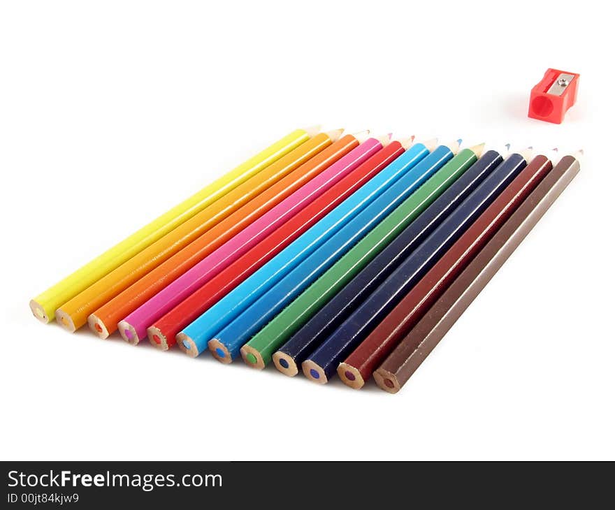 School and office articles: coloured pencils and pencil sharpener on white background