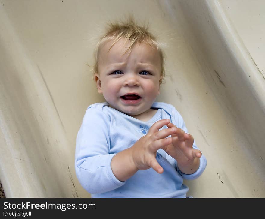 Frustrated baby looks at the camera. He is not crying yet, but he seems like he might cray at any moment.