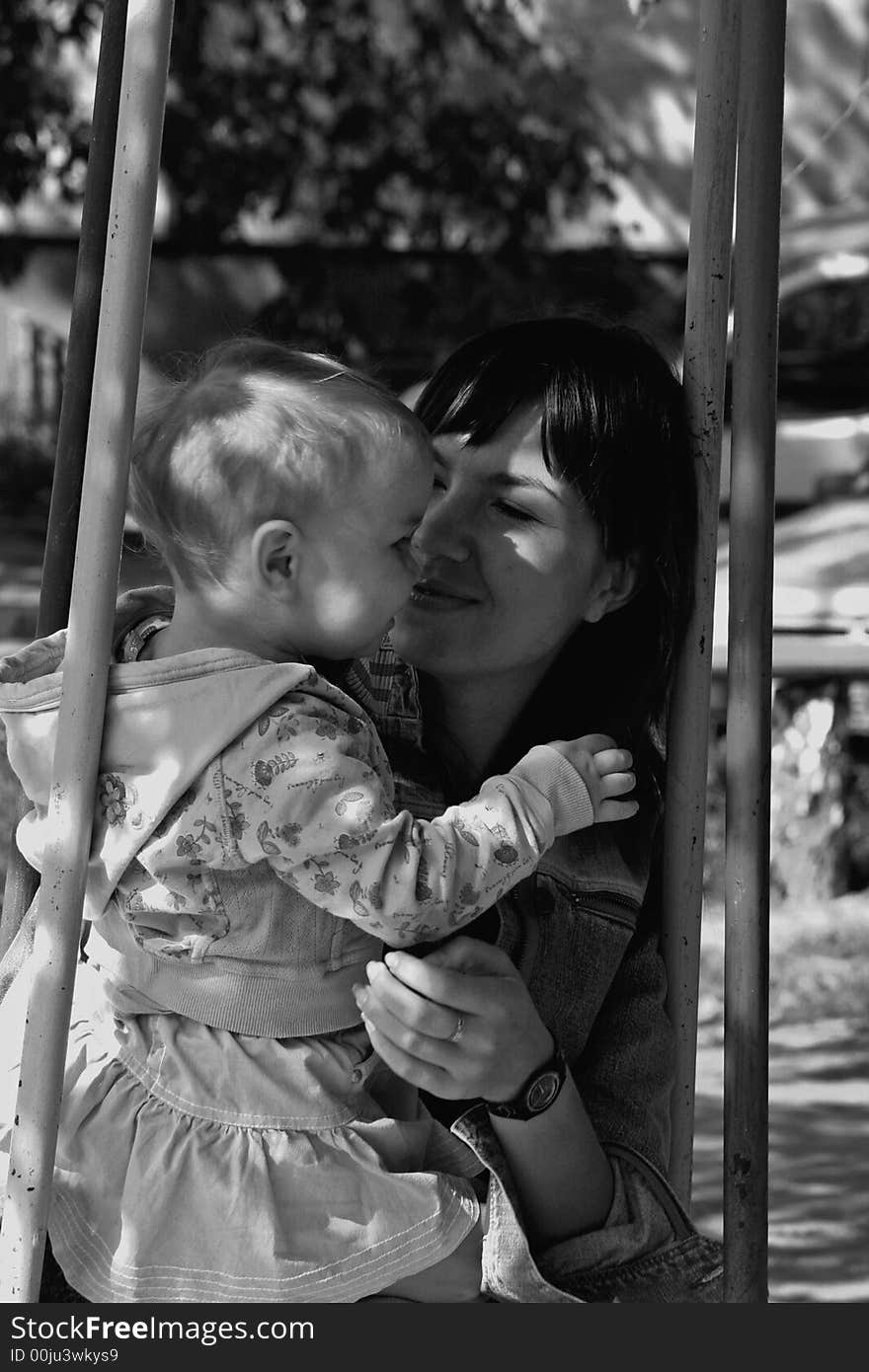 Mother sitting with her daughter and tenderly smiling. Mother sitting with her daughter and tenderly smiling