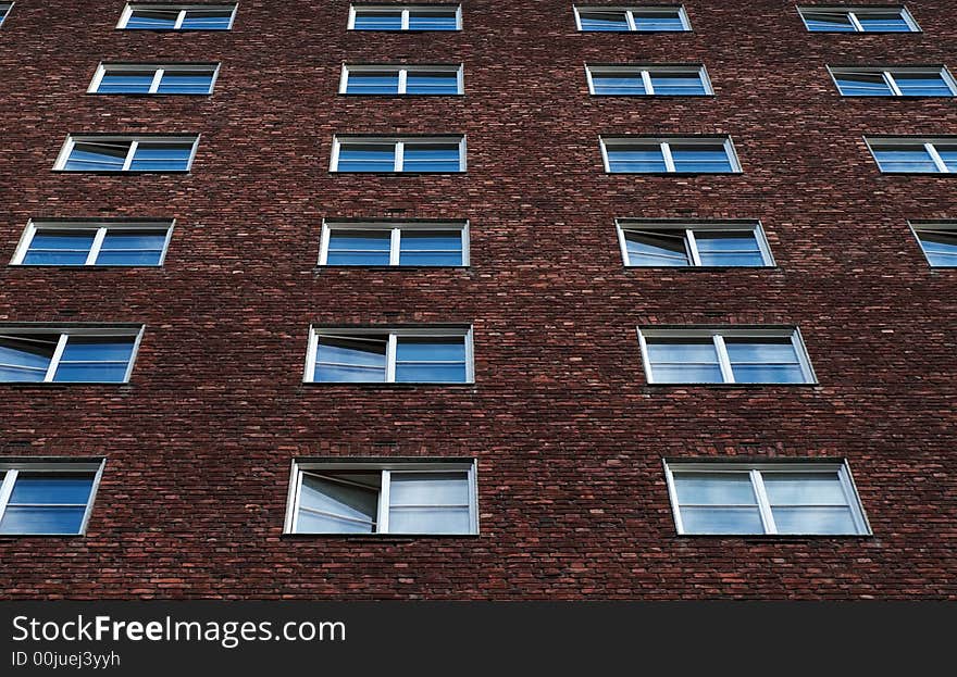 Windows on an apartment building, reflecting the skies above.