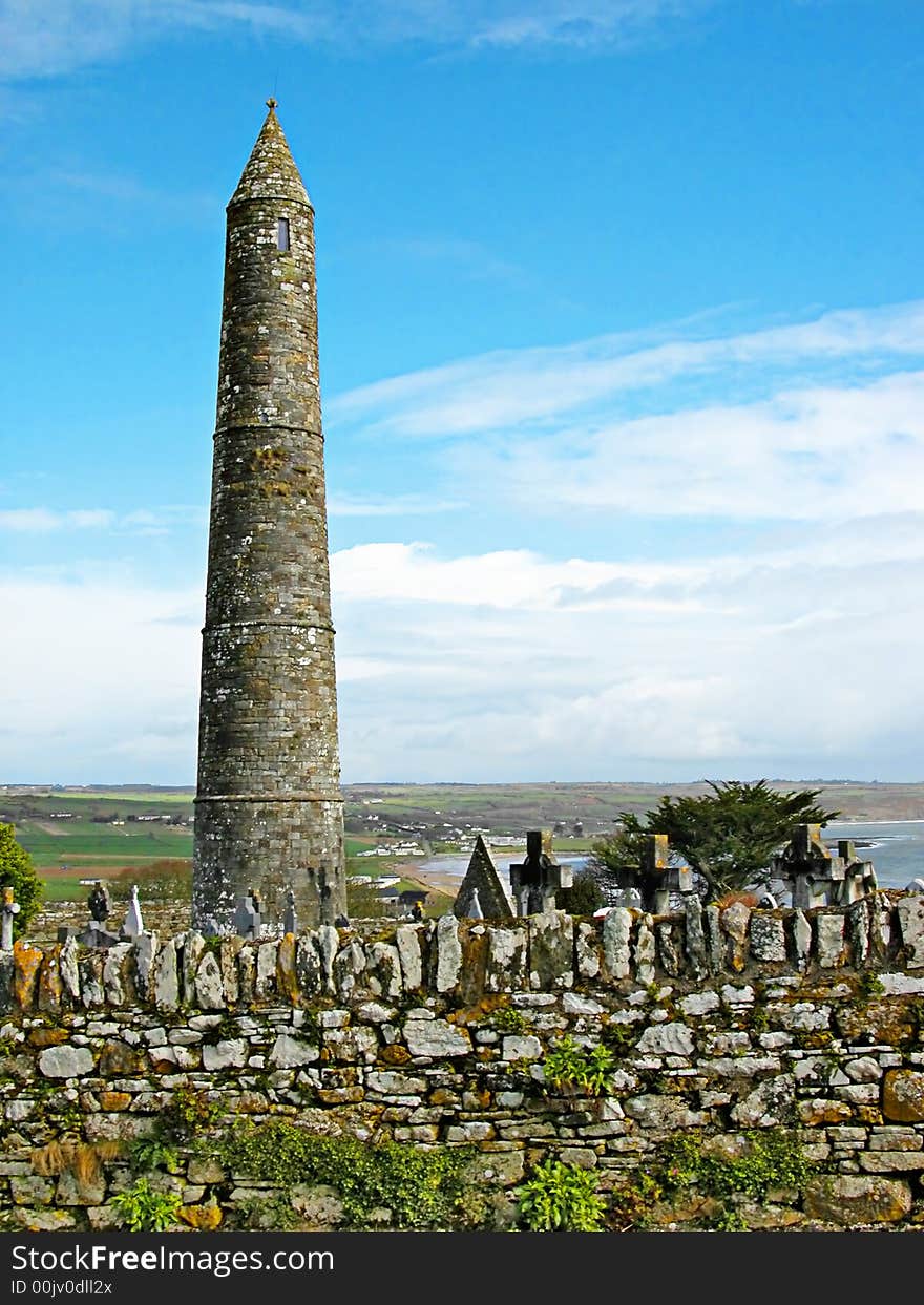 A view of a tipical irish landscape with the grain tower and a small cemetery of a medieval abbey. A view of a tipical irish landscape with the grain tower and a small cemetery of a medieval abbey