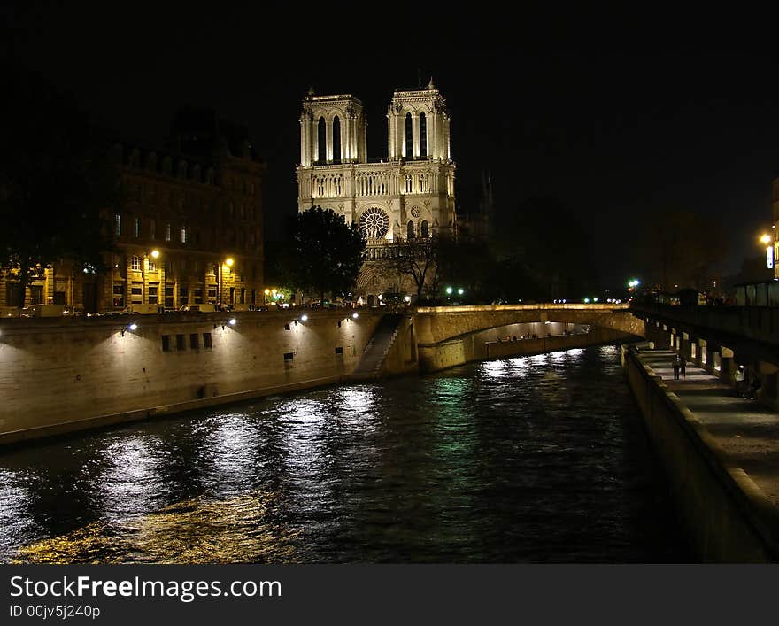 Notre dame de paris at night with the seine river