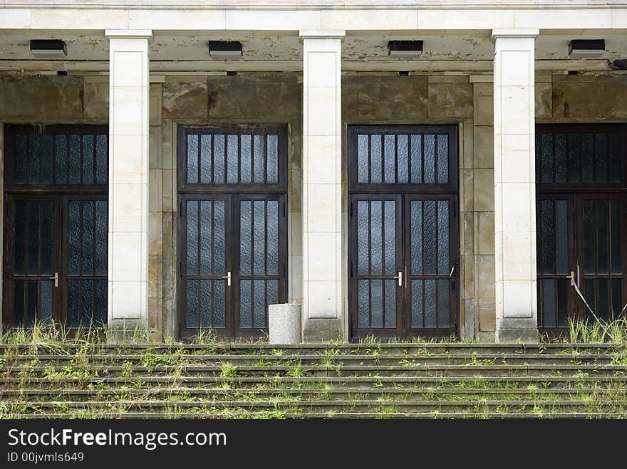 Abandoned hall of the fifities in  Germany, steps covered with weed.