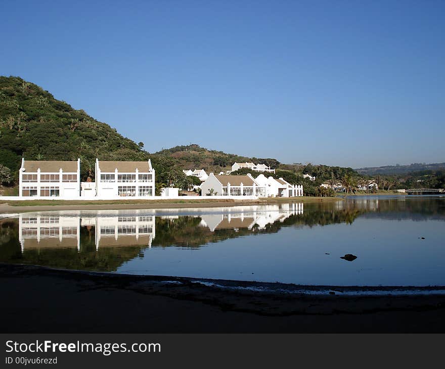 Perfect reflection of house on the calm waters of an African lagoon